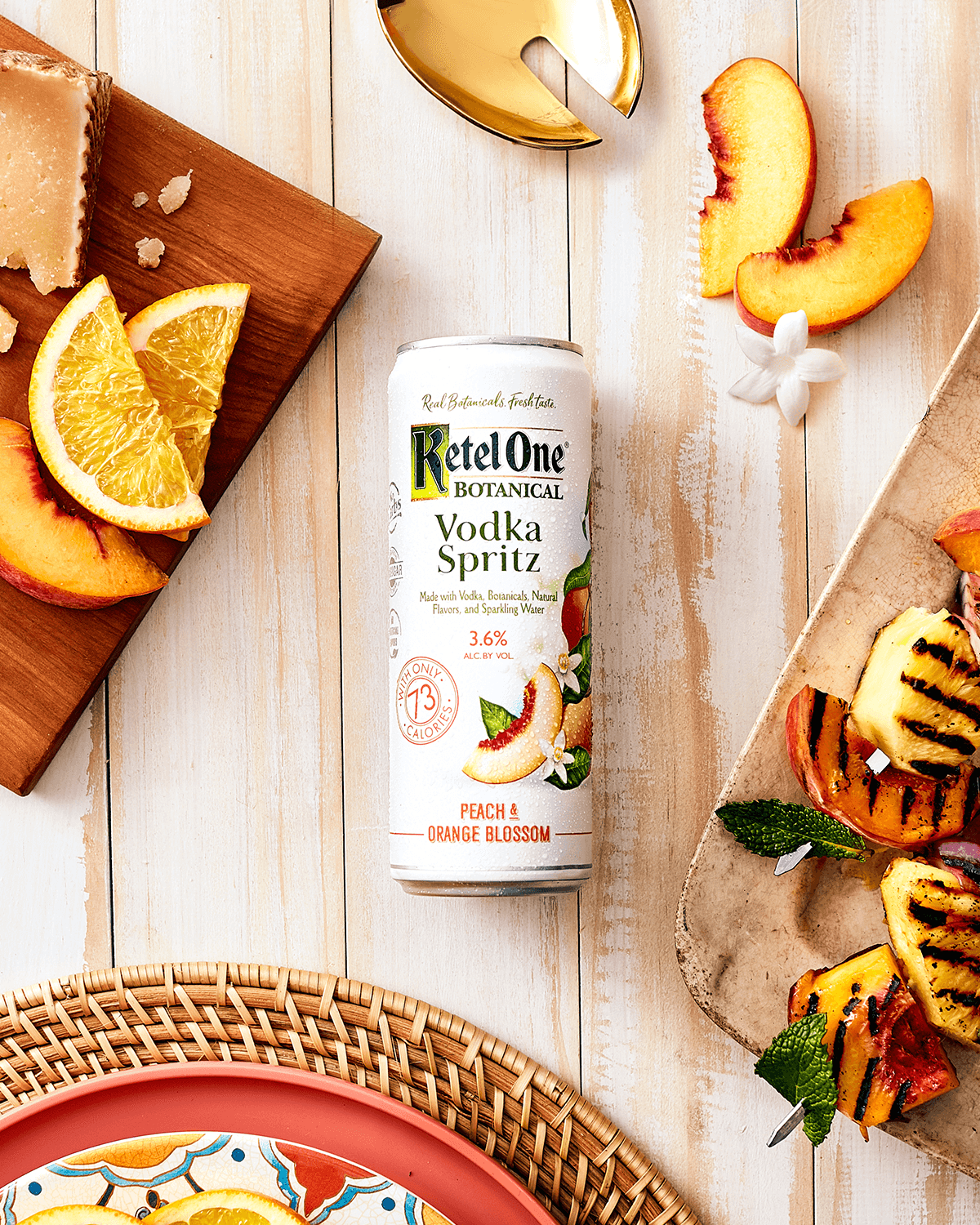 Botanical vodka spritz can arranged with peach and citrus ingredients